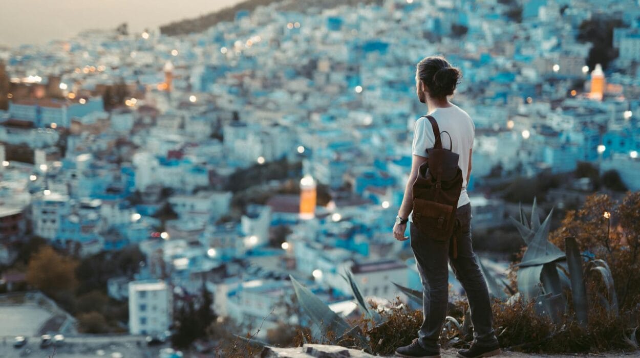 Traveler overlooks the blue city of Chefchaouen at dusk, capturing the vibrant essence of this Moroccan gem.